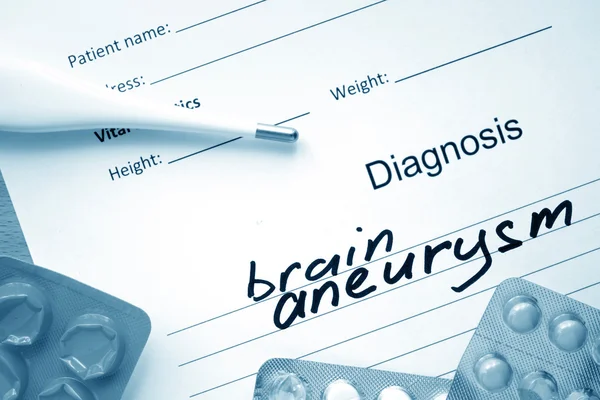 Diagnoseform mit Diagnose Gehirn-Aneurysma und Pillen. — Stockfoto