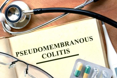 Pseudomembranous colitis concept. Book with stethoscope and pills. clipart