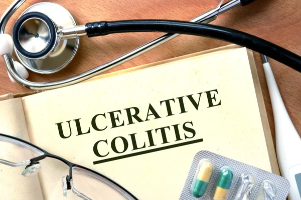 Il concetto di colite ulcerosa. Libro con stetoscopio e pillole . — Foto Stock