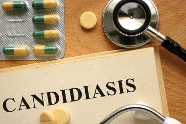 Word Candidiasis  on a book and pills. clipart
