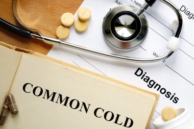 Word Common cold  on a book and pills. clipart