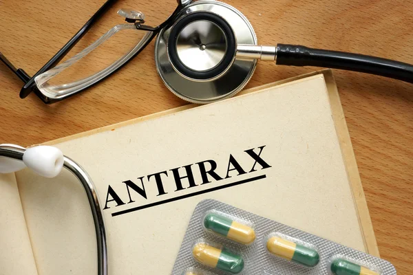 Anthrax mot sur un livre et des pilules . — Photo