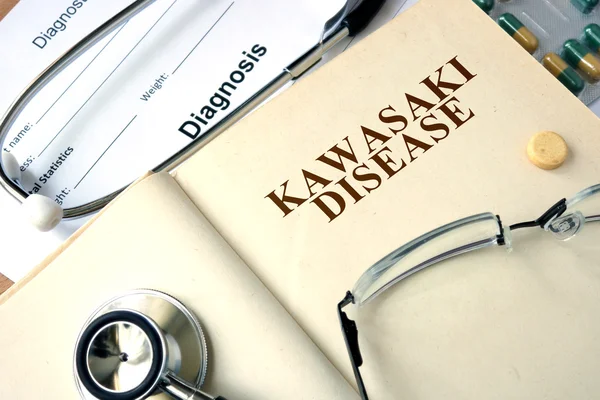 Νόσος Kawasaki λέξη σχετικά με ένα βιβλίο και χάπια. — Φωτογραφία Αρχείου