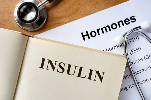 Inzulín slovo napsané na seznamu knihy a hormony. — Stock fotografie