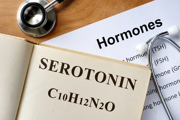 Serotonin steht auf der Liste von Buch und Hormonen. — Stockfoto