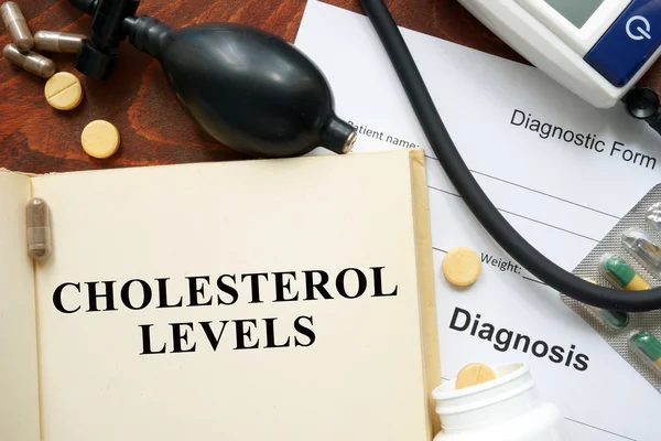Niveles de colesterol escritos en un libro y forma de diagnóstico . —  Fotos de Stock