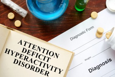attention deficit hyperactivity disorder  written on a book and diagnosis form. clipart