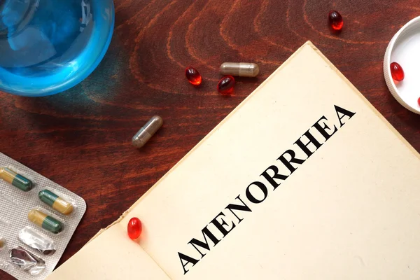 Amenorrhea  written on a book and diagnosis form. — Stock Photo, Image