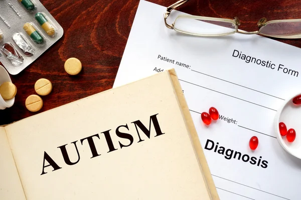 Autism som skrivit en bok och diagnos formuläret. — Stockfoto