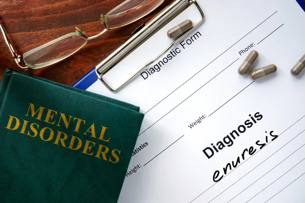 Enuresis concept. Diagnostic form and book on a table. — Stock Photo, Image