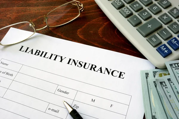 Modulo assicurazione responsabilità civile e dollari sul tavolo . — Foto Stock