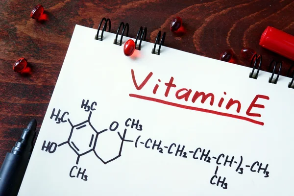 Bloc de notas con vitamina e y pastillas sobre la mesa . —  Fotos de Stock