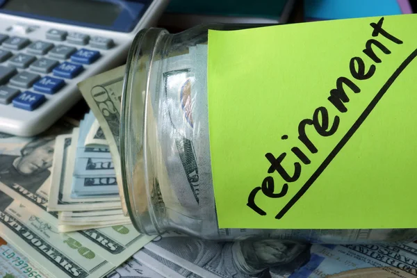 Tarro con etiqueta Plan de Jubilación y dinero sobre la mesa . — Foto de Stock