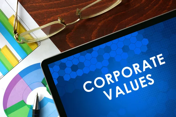 Tableta con valores corporativos sobre una mesa . — Foto de Stock