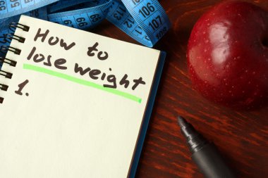 Notebook with how to lose weight    sign.  Diet concept. clipart