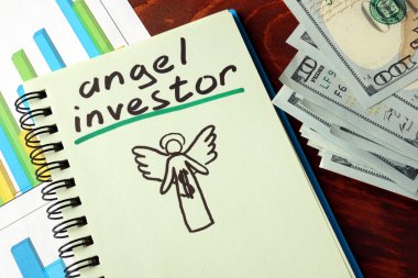 Notebook with angel investors  sign.  Business concept. clipart