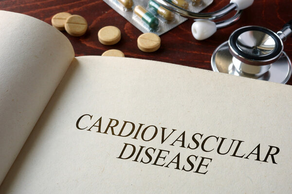 Book with diagnosis cardiovascular disease and pills.