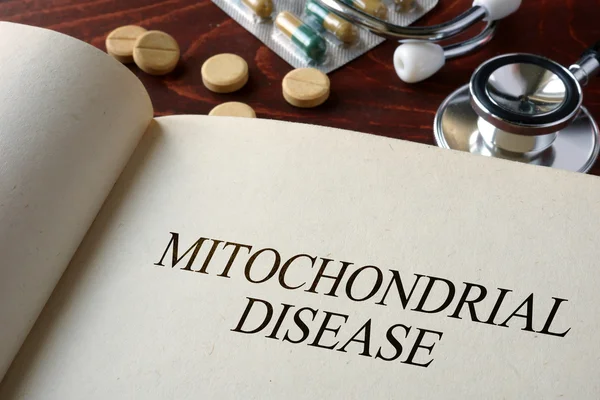 Livre avec diagnostic maladie mitochondriale et pilules . — Photo