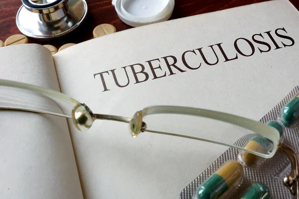 Libro con diagnosi tubercolosi e pillole . — Foto Stock