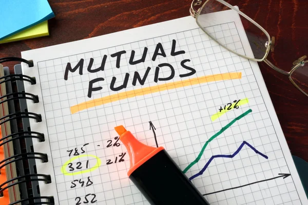 Notebook s podílových fondů se znaménkem na stůl. Podnikatelský koncept. — Stock fotografie