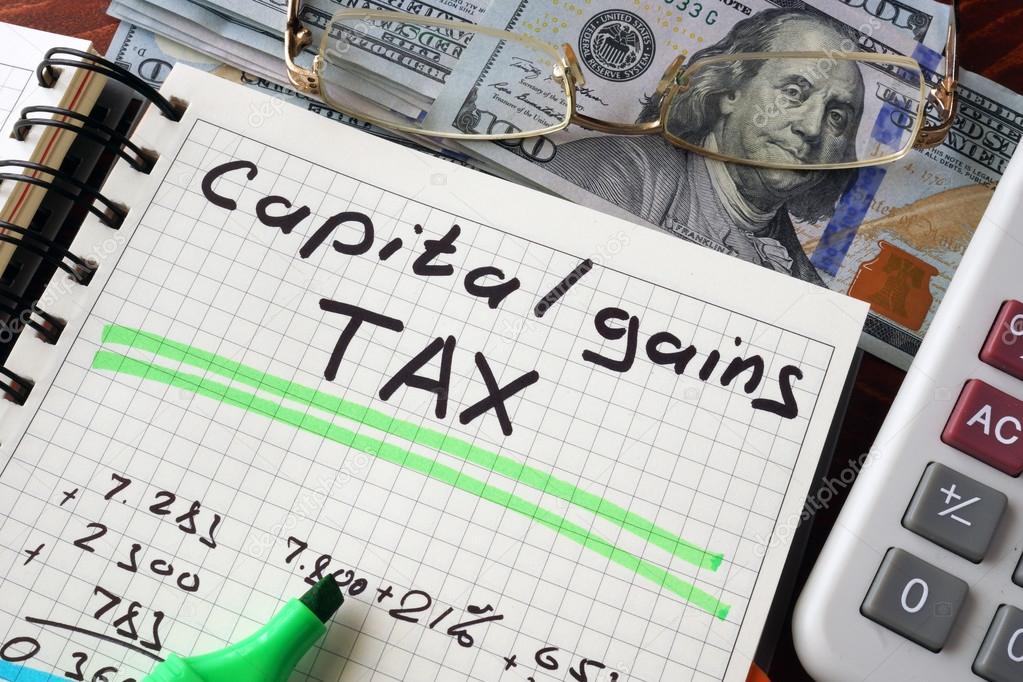Notebook with capital gains tax  sign on a table. Business concept.