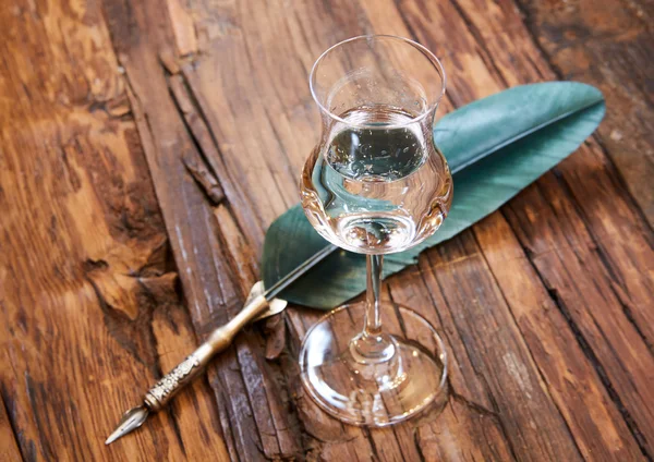 Grappa in a small glas on old wooden table — Stock Photo, Image