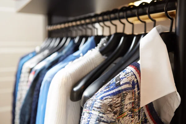 Kleding aan hangers in de winkel. — Stockfoto