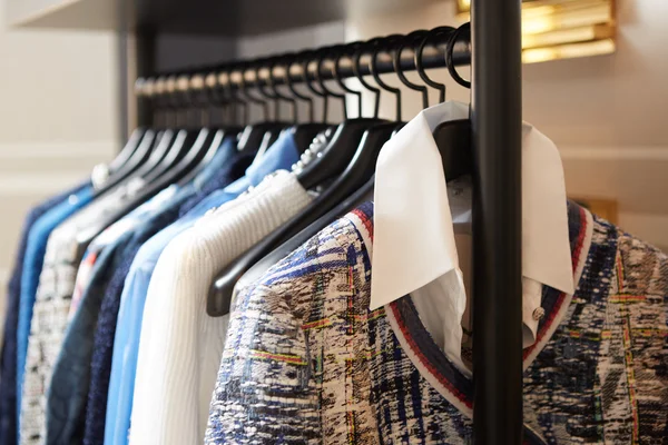 Ropa en perchas en tienda. — Foto de Stock