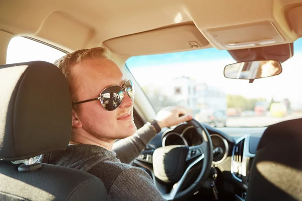 Knappe man rijden auto dragen van een zonnebril — Stockfoto