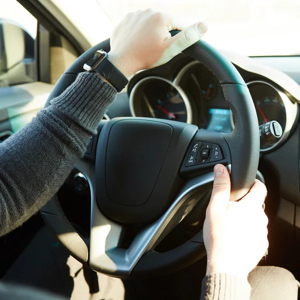 Primer plano de un hombre con las manos sosteniendo el volante mientras conduce el coche — Foto de Stock