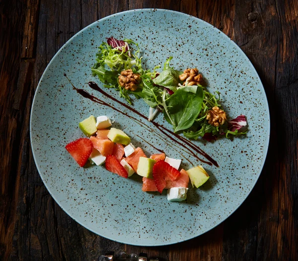 Salad with strawberries, salmon, cheese and walnuts — Stock Photo, Image