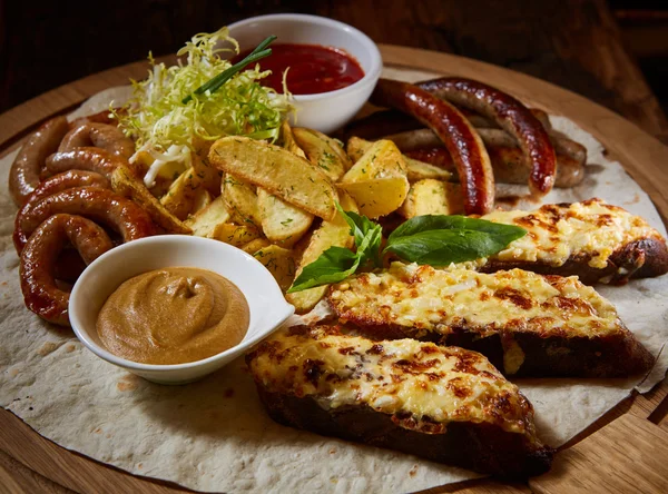 Geassorteerde gebakken worstjes, aardappelen, gegrilde Adjika, saus van mosterd saus — Stockfoto