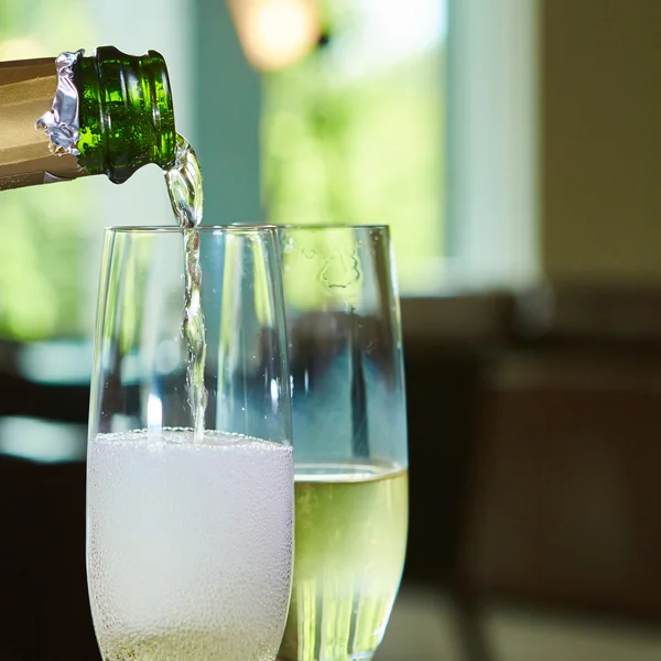 Champagne pouring in two glasses — Stock Photo, Image