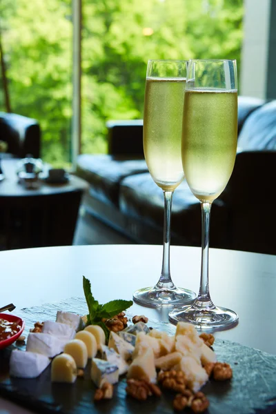 Dvě sklenice šampaňského zásobníku sýrem — Stock fotografie