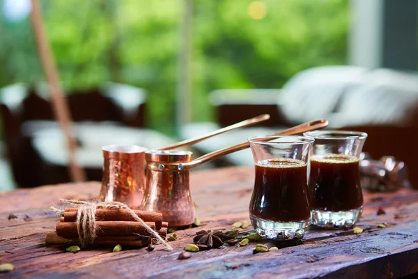 Despejar o café árabe em xícaras no fundo de madeira . — Fotografia de Stock