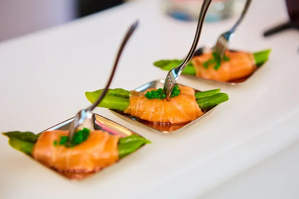 Placa de aperitivo de espárragos salteados envueltos en finas rebanadas de salmón ahumado — Foto de Stock