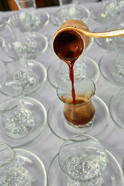 Pouring turkish coffee into traditional embossed cup. — Stock Photo, Image
