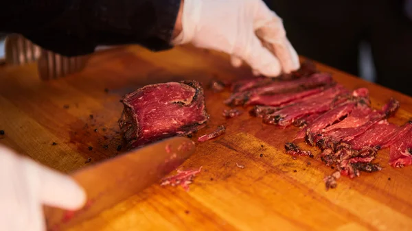 Butcher cutting slices of fresh beef — Stock Photo, Image