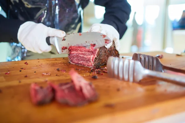 Butcher cutting slices of fresh beef — Stock Photo, Image