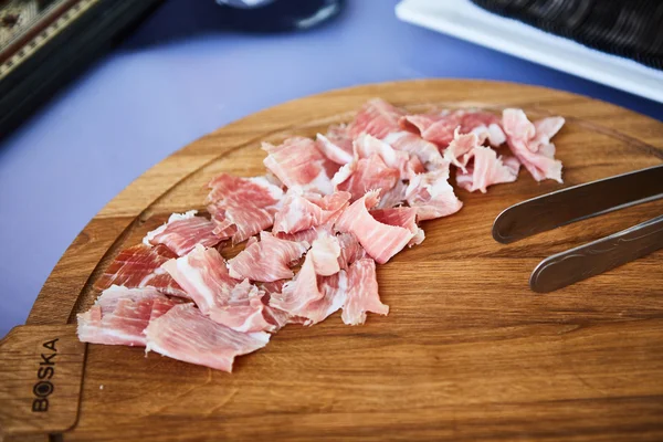 Prosciutto tranché sur une planche de bois — Photo