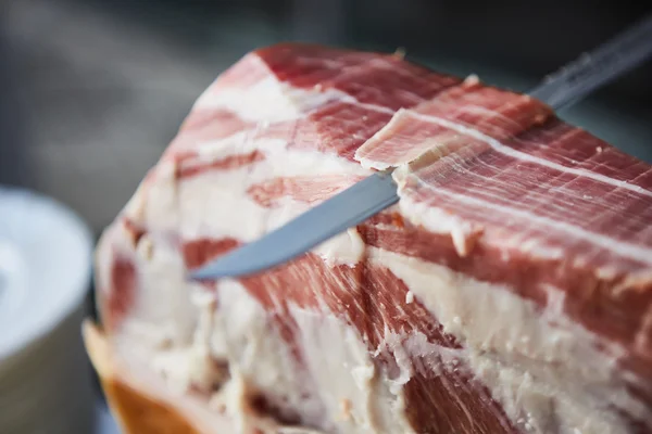 Chef slices serrano ham. — Stock Photo, Image