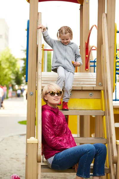Mother and daughter playing on the playground outdoors — Stock Photo, Image