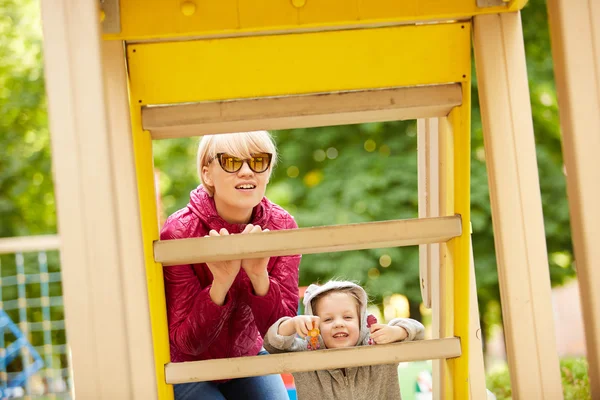 Moeder en dochter spelen op de speelplaats buiten — Stockfoto