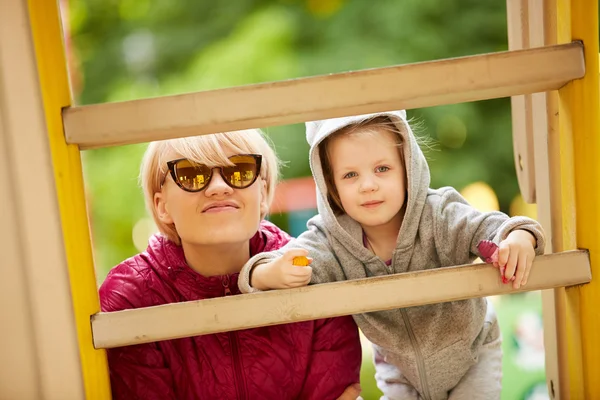 Moeder en dochter spelen op de speelplaats buiten — Stockfoto