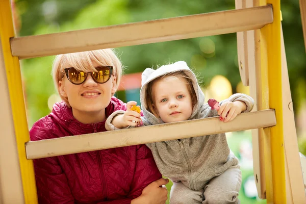 Moeder en dochter spelen op de speelplaats buiten — Stockfoto