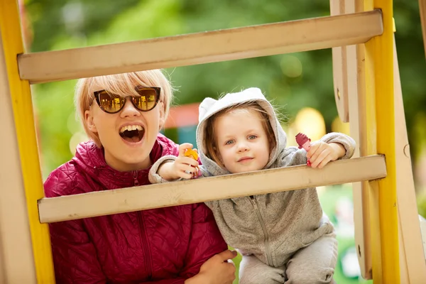 Mother and daughter playing on the playground outdoors — Stock Photo, Image