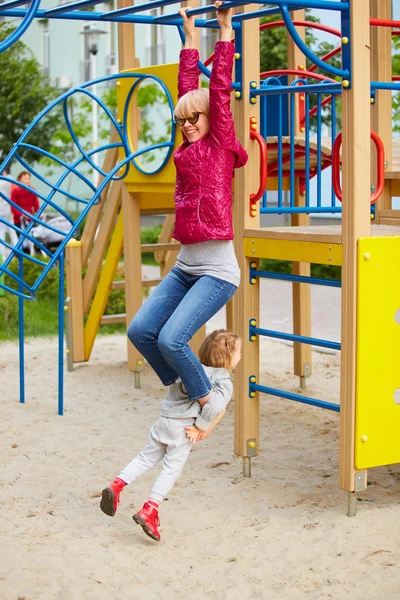 Mãe e filha brincando no playground ao ar livre — Fotografia de Stock