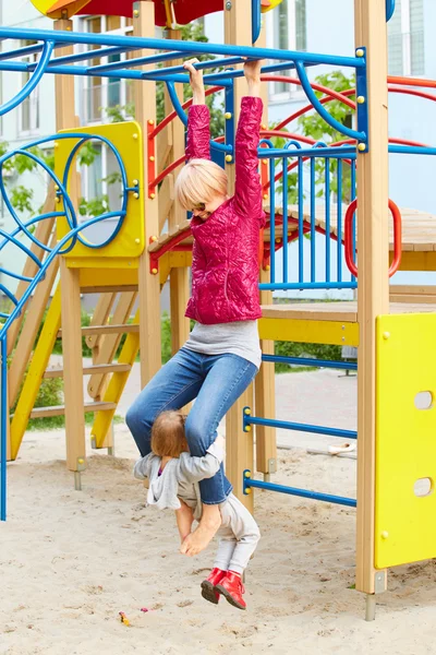 Mor och dotter spelar på lekplatsen utomhus — Stockfoto