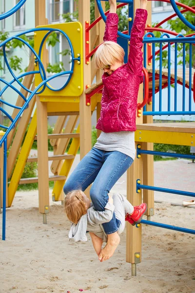 Moeder en dochter spelen op de speelplaats buiten — Stockfoto