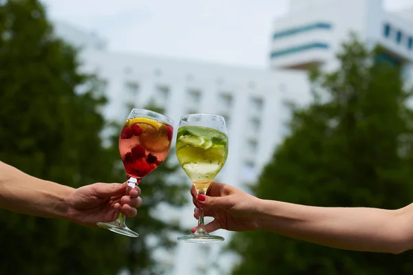 Hand som håller glasen cocktail spottar tillsammans på utomhus. — Stockfoto